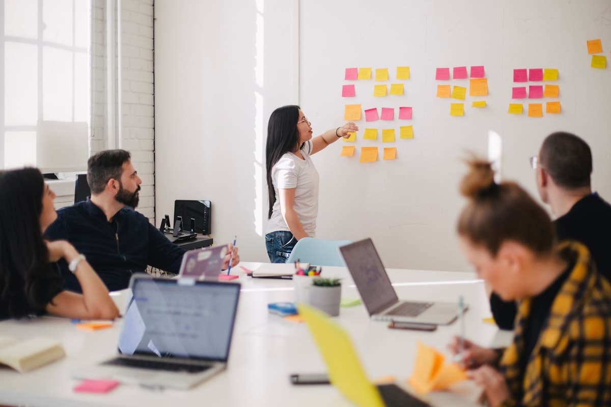 Team mapping out a project roadmap with sticky notes on a whiteboard
